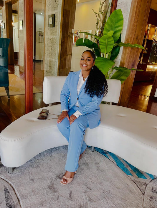 Sky blue blazer + matching flared pants suit on model seated on white curved bench